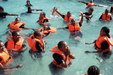Enfants africains apprenant à nager dans un bassin mobile installé par la CANA