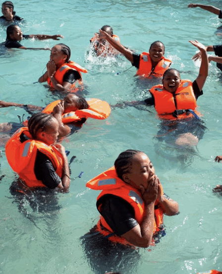 Enfants africains apprenant à nager dans un bassin mobile installé par la CANA