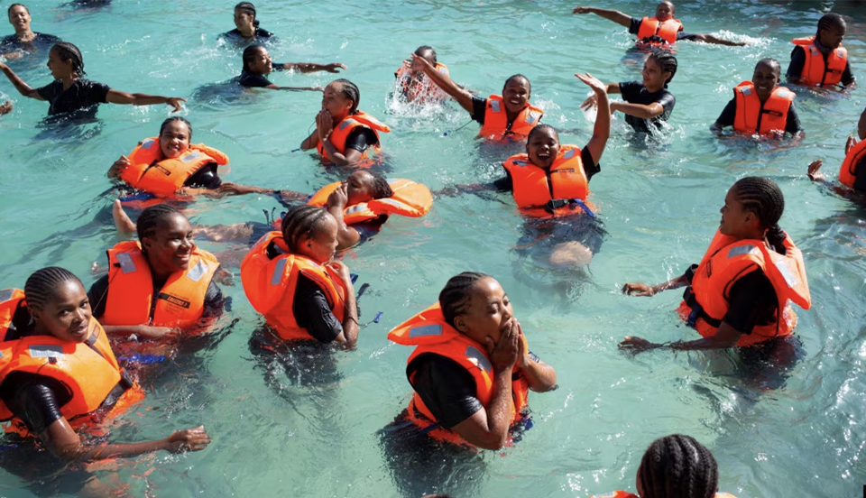 Enfants africains apprenant à nager dans un bassin mobile installé par la CANA
