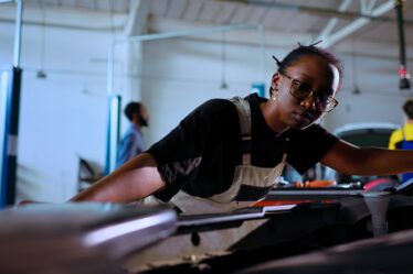 Femme mécanicienne effectuant la maintenance d'un avion dans un hangar en Afrique